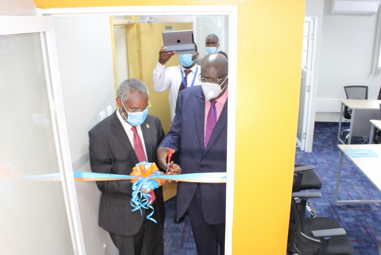 Education Cabinet Secretary Prof. George Magoha(R) and University of Nairobi Vice Chancellor Prof. Stephen Kiama cut the ribbon to officially open the CEMA Data Science Lab.