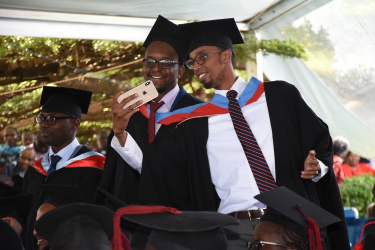 Graduands take selfies during 62 graduation ceremony.