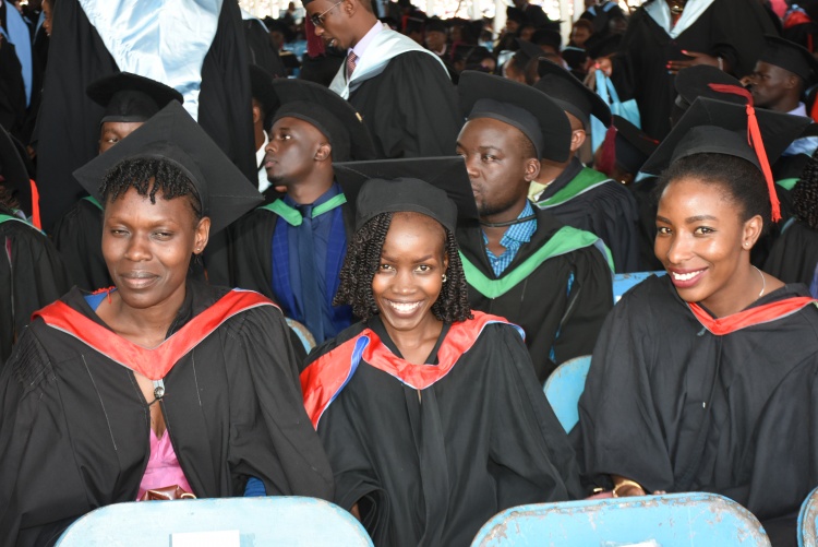 Graduands keenly follow graduation proceeding with smiles on their faces.