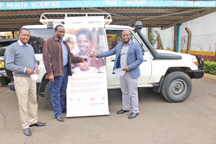 Christian Aid Country Manager Njoroge Mucheru (far right) hands over car keys to Prof. James Machoki, Dean Faculty of Health Sciences, looking on is Joseph Waigwi, Faculty Registrar.