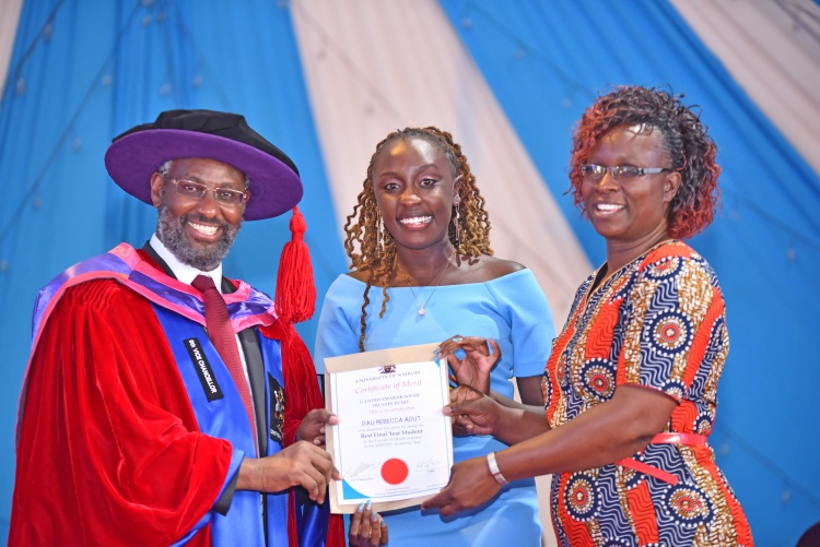Vice Chancellor Prof. Stephen Kiama (L) awards Dau Rebbeca Adut after emerging as the best final year student.