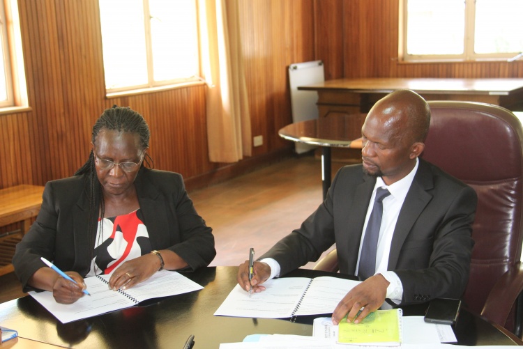 Faculty of Health Sciences Dean Prof. George Osanjo(R) with Prof. Joyce Olenja, Chair Department of Global Health during the signing of the 2022/2023 performance contract.