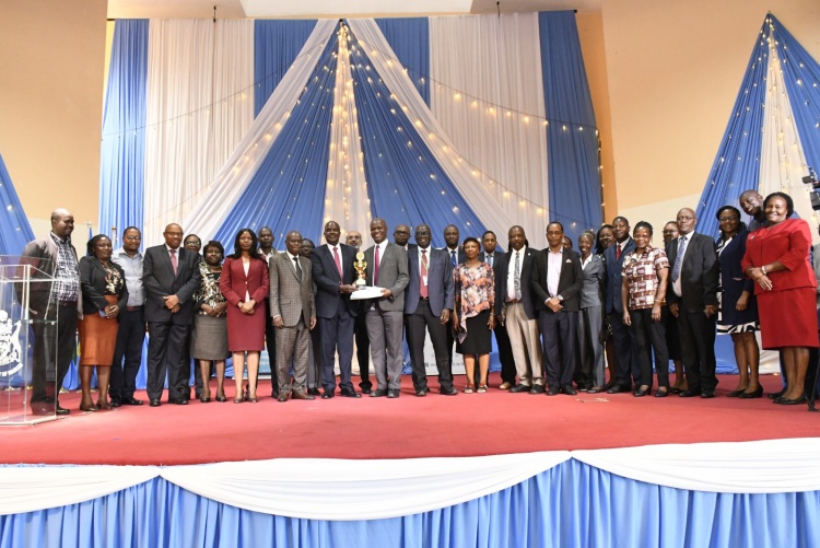 FHS Dean Prof. Daniel Ojuka receiving the award for best faculty and flanked by staff members of the faculty.